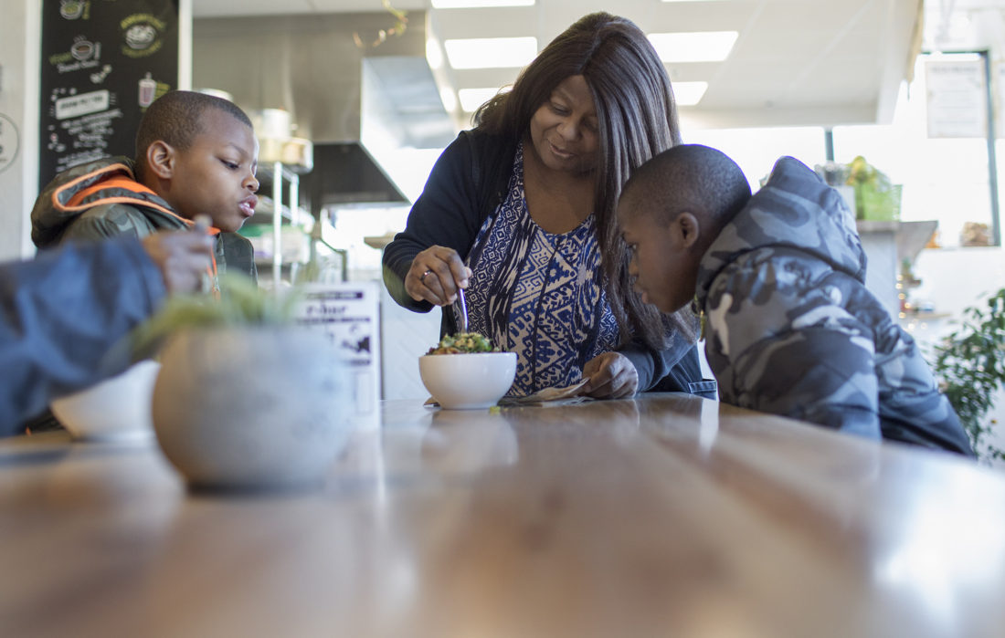 Everel Watson, 46, and her sons, Ethaniah, 10, and Edakiah, share a Korean cauliflower dish eat at R. House in the Remington neighborhood of Baltimore. R. House is an upscale food court style eatery with a variety of different vendors.