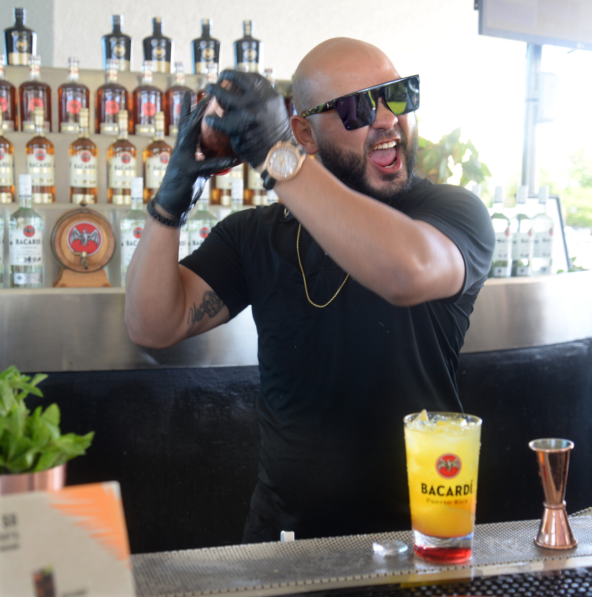 A Bacardi bartender plays to the crowd as he makes a Rum Sunrise at a visitor's area outside the Bacardi distillery. Photo by Sarah Price