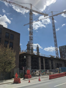 Idled cranes soar over a hi-rise that has halted construction on College Ave in Downtown State College. Photo by Lesley Cosme